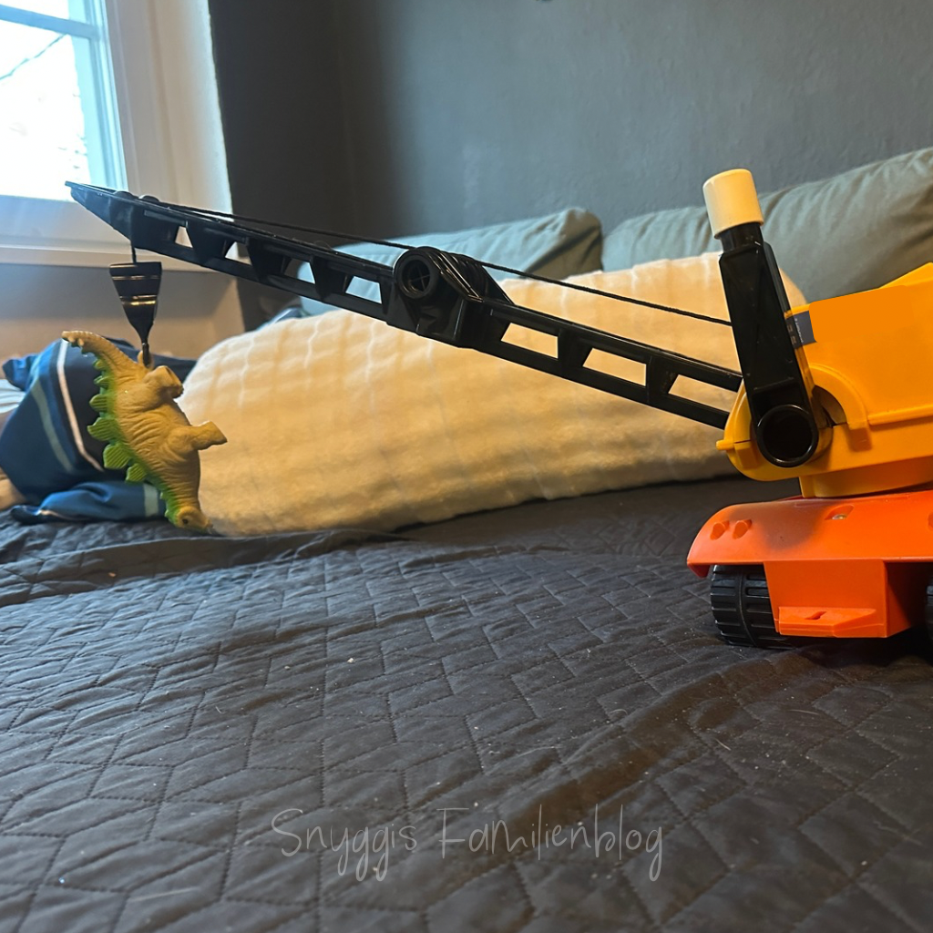 2 von 12 - Dino wird abgeschleppt. Kranwagen und Stegosaurus auf Couch