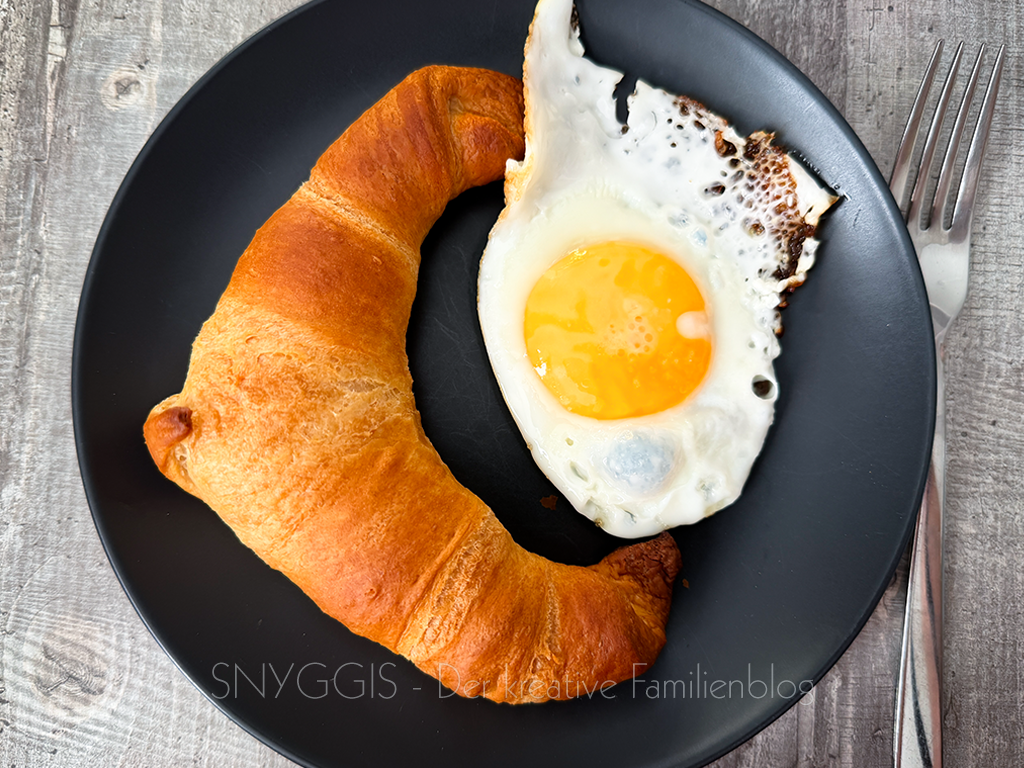 Frühstück mit Croissants und Spiegeleiern